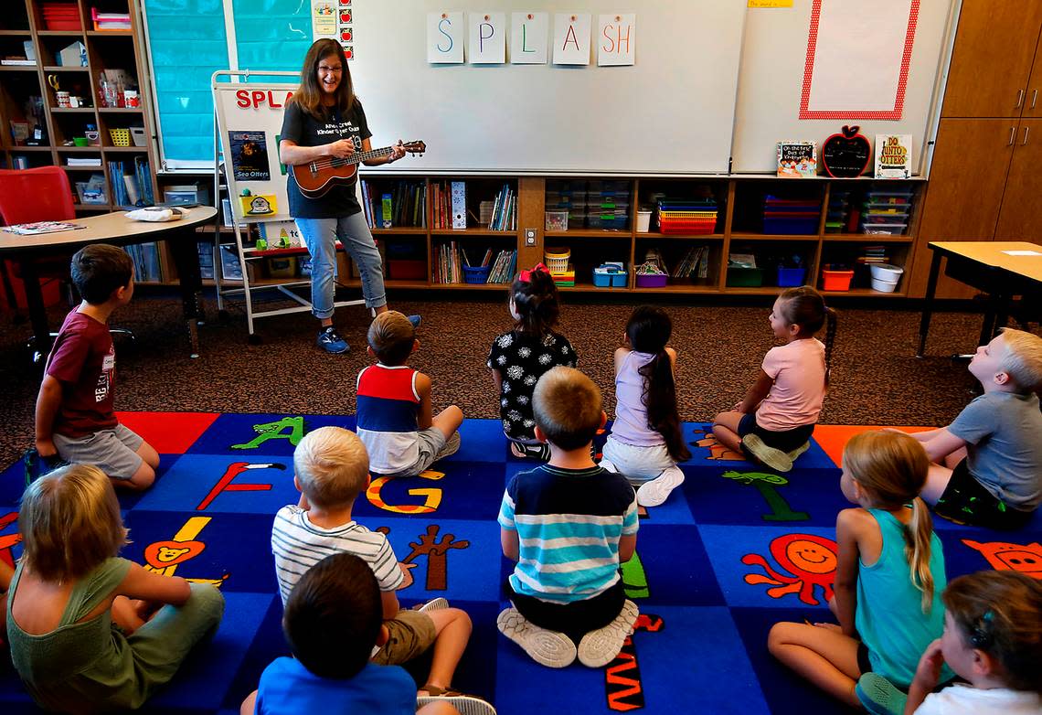 Teacher Julie Bruce plays her ukulele during a sing-along with her new kindergarten students during Wednesday’s visit at Amon Creek Elementary School. In an effort to get kids, parents and teachers ready for the school year, the Kennewick School District is hosting several days of classroom visits for kindergartners. Bob Brawdy/bbrawdy@tricityherald.com