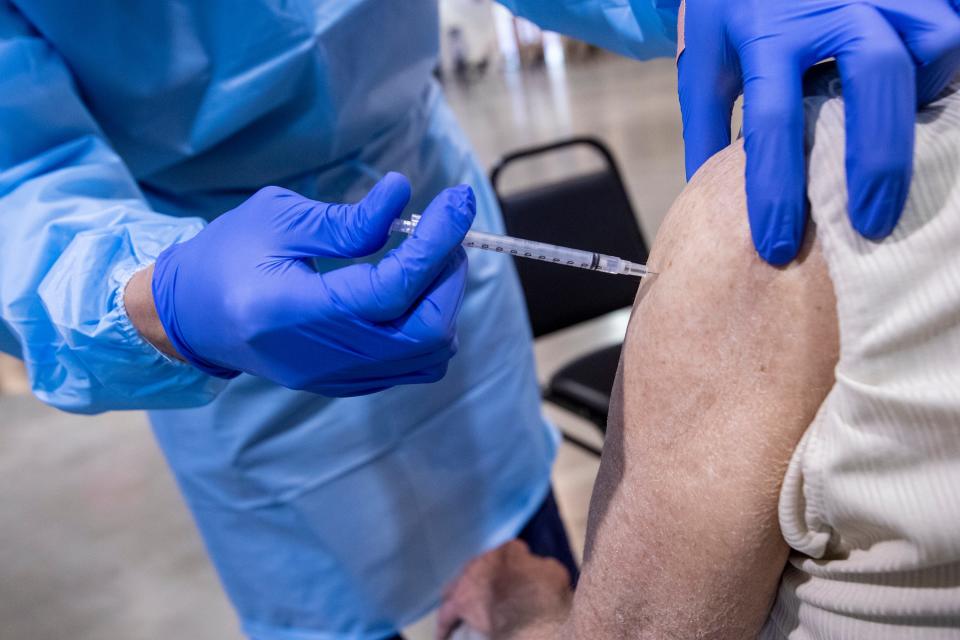 Registered nurse Ram Rengel administers a COVID-19 vaccine at a Riverside County run clinic in Indio, Calif., on February 10, 2021.  