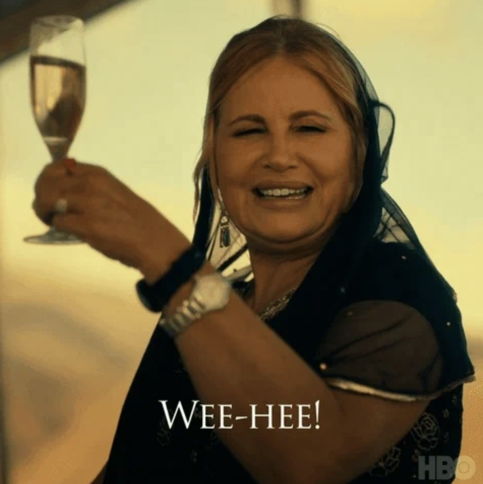 Jennifer Coolidge in a black veil holding up a champagne and saying "wee-hee"