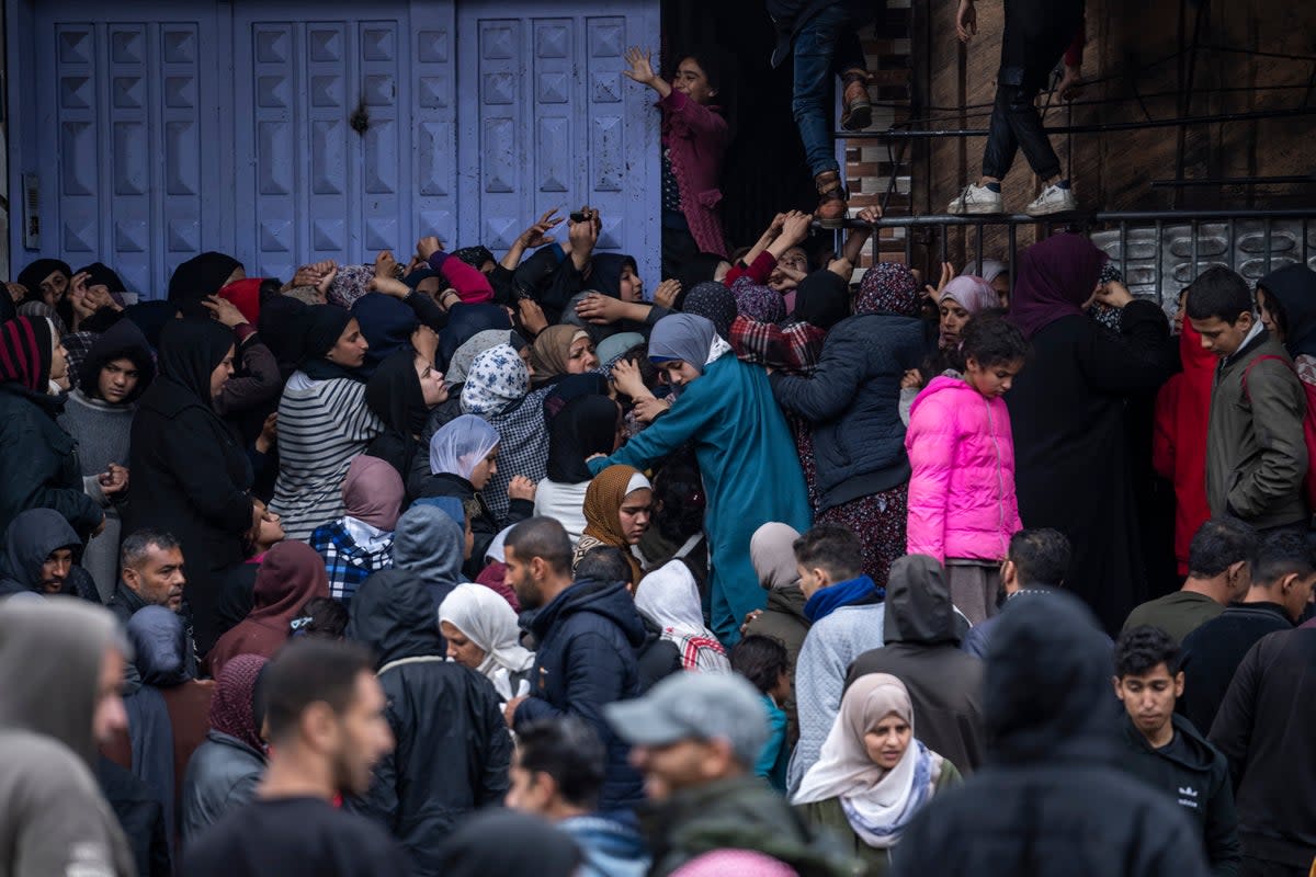 Palestinian crowds struggle to buy bread from a bakery in Rafah (AP)