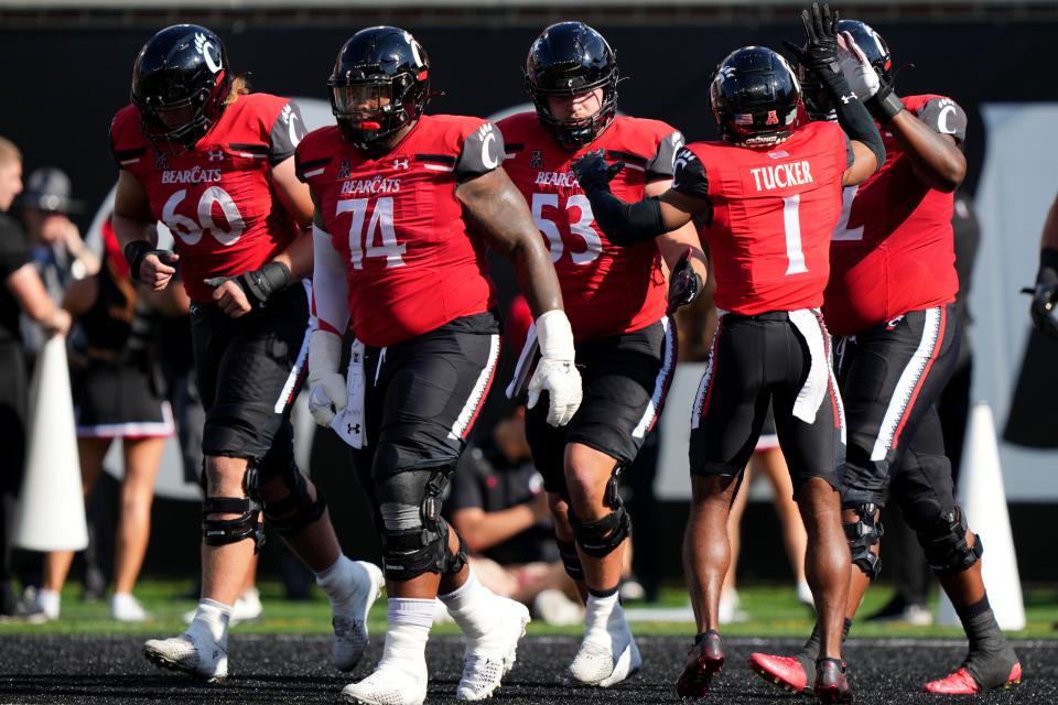 Cincinnati Bearcats wide receiver Tre Tucker (1) congratulates the offensive line after scoring a touchdown in the second quarter of a college football game against the Indiana Hoosiers, Saturday, Sept. 24, 2022, at Nippert Stadium in Cincinnati. 