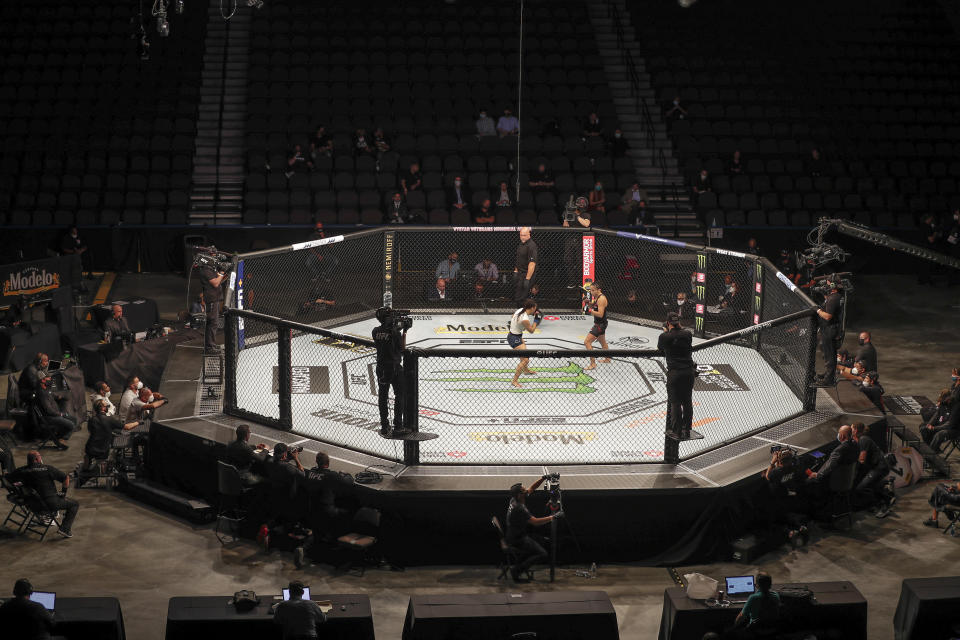 Michelle Waterson, center left, and Carla Esparza battle without spectators during a UFC 249 mixed martial arts bout, Saturday, May 9, 2020, in Jacksonville, Fla. (AP Photo/John Raoux)