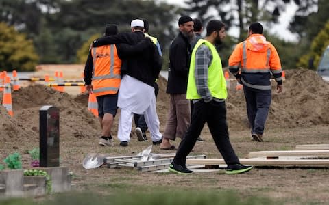 Muslims embrace after overseeing the excavating of graves at a Muslim cemetery in Christchurch, New Zealand - Credit: AP