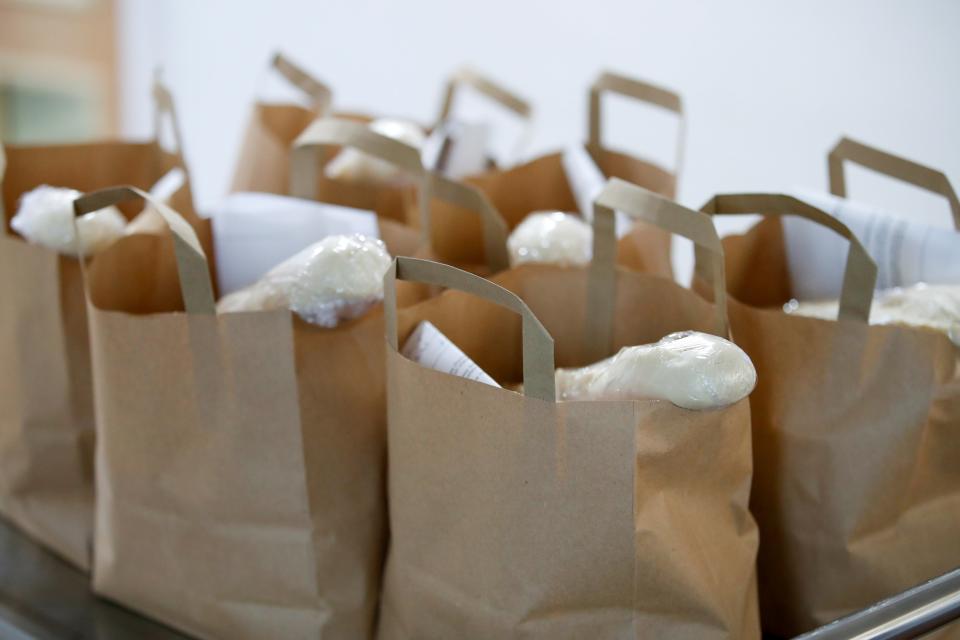 Food parcels for families that received free school meal vouchers during previous lockdowns rest on a tray before being delivered (Reuters)