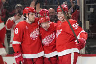 Detroit Red Wings left wing Lucas Raymond, center, celebrates his goal with Ben Chiarot, left, and Moritz Seider, right, in the third period of an NHL hockey game against the Buffalo Sabres, Saturday, March 16, 2024, in Detroit. (AP Photo/Paul Sancya)