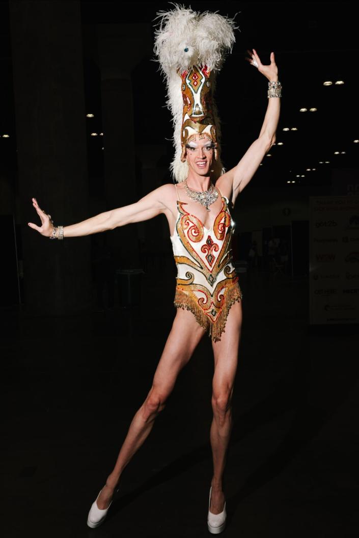 A person in a costume with a horse head hat, poses for the camera.