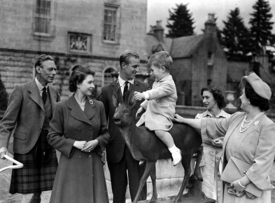 FILE - Britain's Prince Charles, watched by, from left, King George VI, Princess Elizabeth, Prince Philip, Princess Margaret and Queen Elizabeth, sits on a sculpture of a deer in the grounds of Balmoral Castle, Scotland, Aug. 1951. Queen Elizabeth II will mark 70 years on the throne Sunday, Feb. 6, 2022, an unprecedented reign that has made her a symbol of stability as the United Kingdom navigated an age of uncertainty. (AP Photo, File)