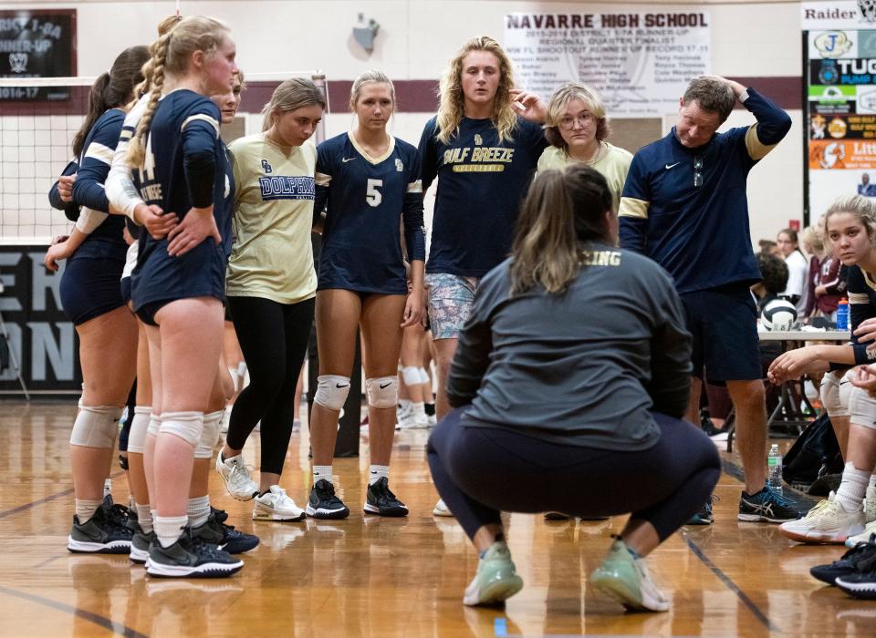 The Gulf Breeze High coaching staff offers their players courtside encouragement during Thursday night's match against Navarre High.