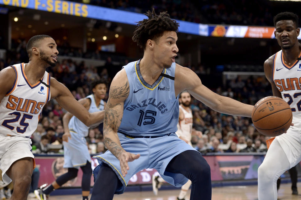 Memphis Grizzlies forward Brandon Clarke (15) steals the ball between Phoenix Suns forward Mikal Bridges (25) and center Deandre Ayton (22) in the second half of an NBA basketball game Sunday, Jan. 26, 2020, in Memphis, Tenn. (AP Photo/Brandon Dill)