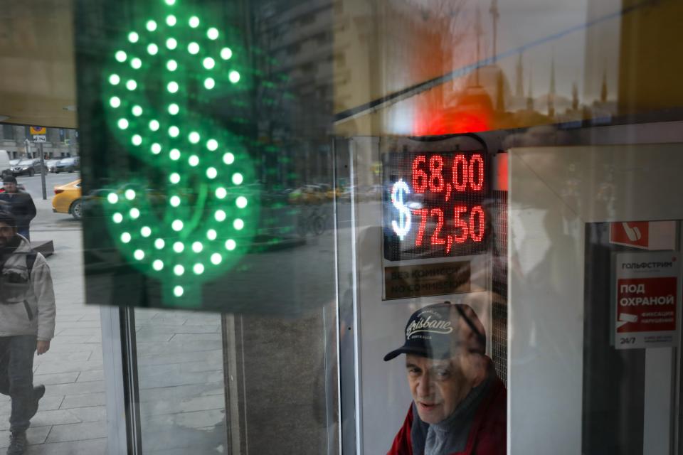 A man stands at an exchange office screen showing the currency exchange rates of U.S. Dollar and Euro to Russian Rubles in Moscow, Russia, Tuesday, March 10, 2020. Oil prices are plunging after Saudi Arabia started a price war against Russia. The Saudis tried to get the Russians to cut oil production to keep prices from falling even more due to the coronavirus. (AP Photo/Pavel Golovkin)