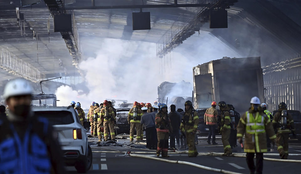 Firefighters work to extinguish a fire on a highway in Gwacheon, South Korea, Thursday, Dec. 29, 2022. A freight truck collided with a bus on a highway near Seoul on Thursday, causing a fire that killed multiple people and injuring dozens of others, officials said. (Kim Jong-taik/Newsis via AP)