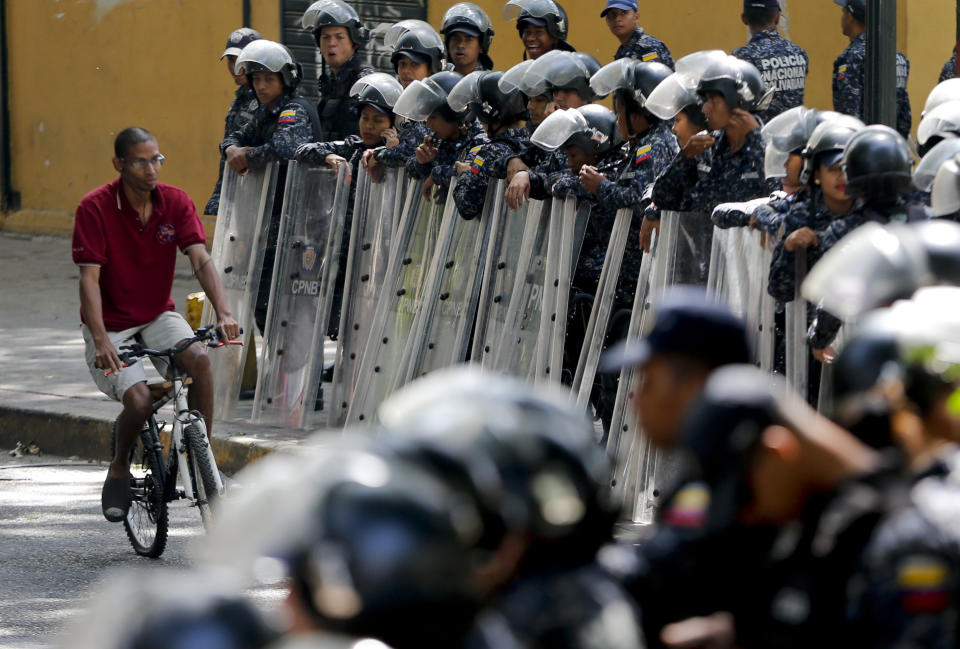 Police stand guard in anticipation of a march called by a coalition of opposition parties and civic groups who are petitioning lawmakers for a law of guarantees that will protect workers who have been victims of political retaliation and unjustified dismissals, in Caracas, Venezuela, Tuesday, March 19, 2019. (AP Photo/Natacha Pisarenko)