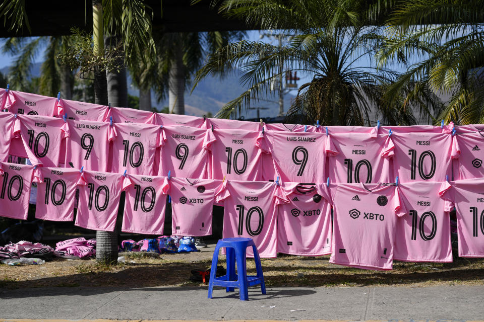 Camisetas de Lionel Messi y Luis Suárez se exhiben a la venta frente al estadio Cuscalán, antes de un partido amistoso entre el Inter de Miami y la selección de El Salvador, el viernes 19 de enero de 2024 (AP Foto/Moisés Castillo)