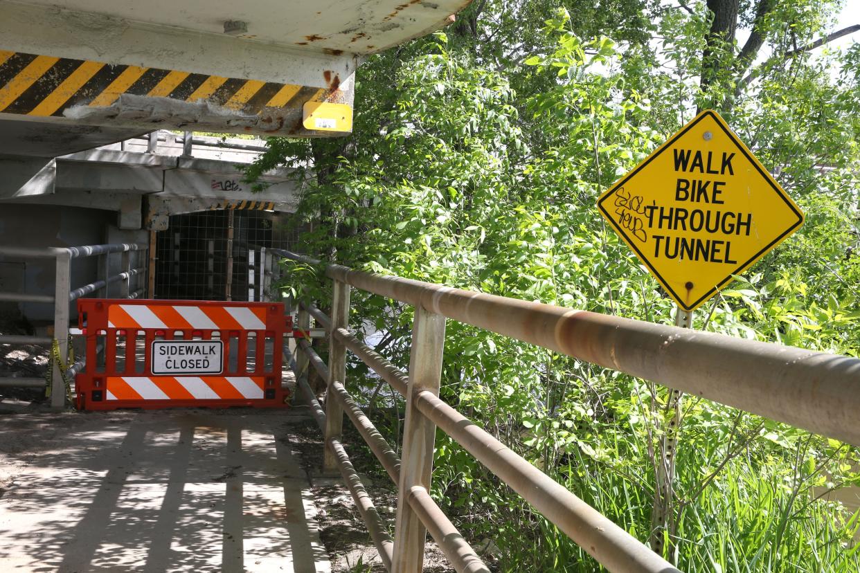 A sign signals the closure of the pedestrian tunnel under the Iowa Avenue bridge in Iowa City.