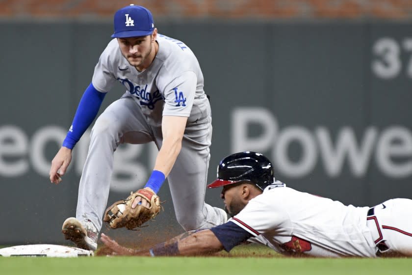 Atlanta, GA - October 17: Atlanta Braves' Eddie Rosario dives into second base ahead of the tag by Los Angeles Dodgers second baseman Trea Turner off a pop out by Freddie Freeman during the eighth inning in game two in the 2021 National League Championship Series at Truist Park on Sunday, Oct. 17, 2021 in Atlanta, GA.(Wally Skalij / Los Angeles Times)