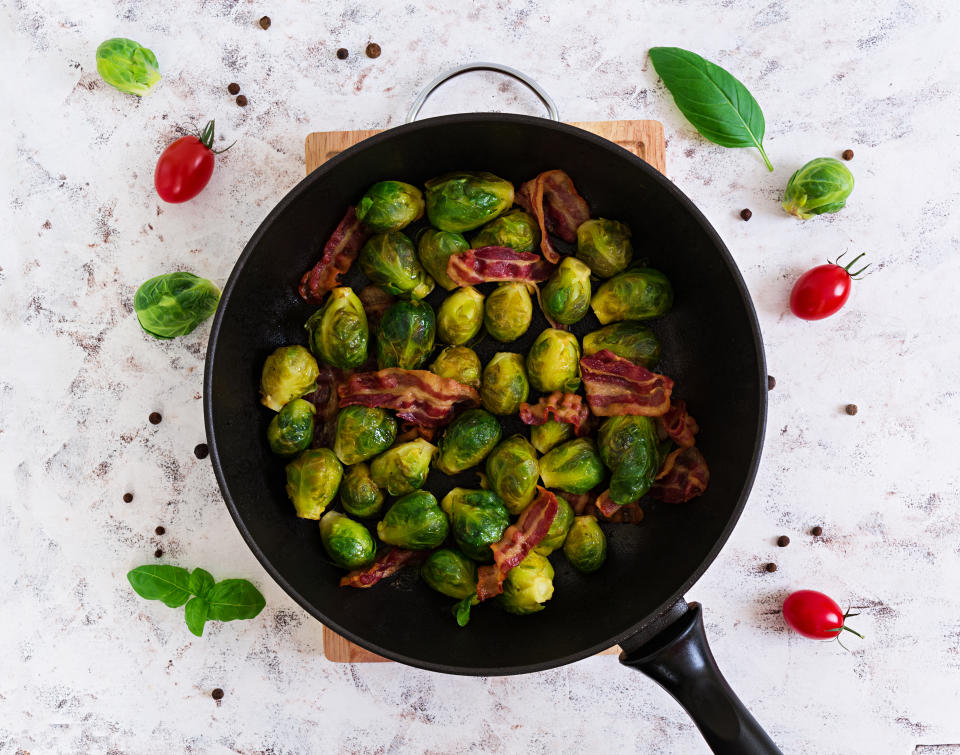 Roasted brussels sprouts with bacon on white background. Top view