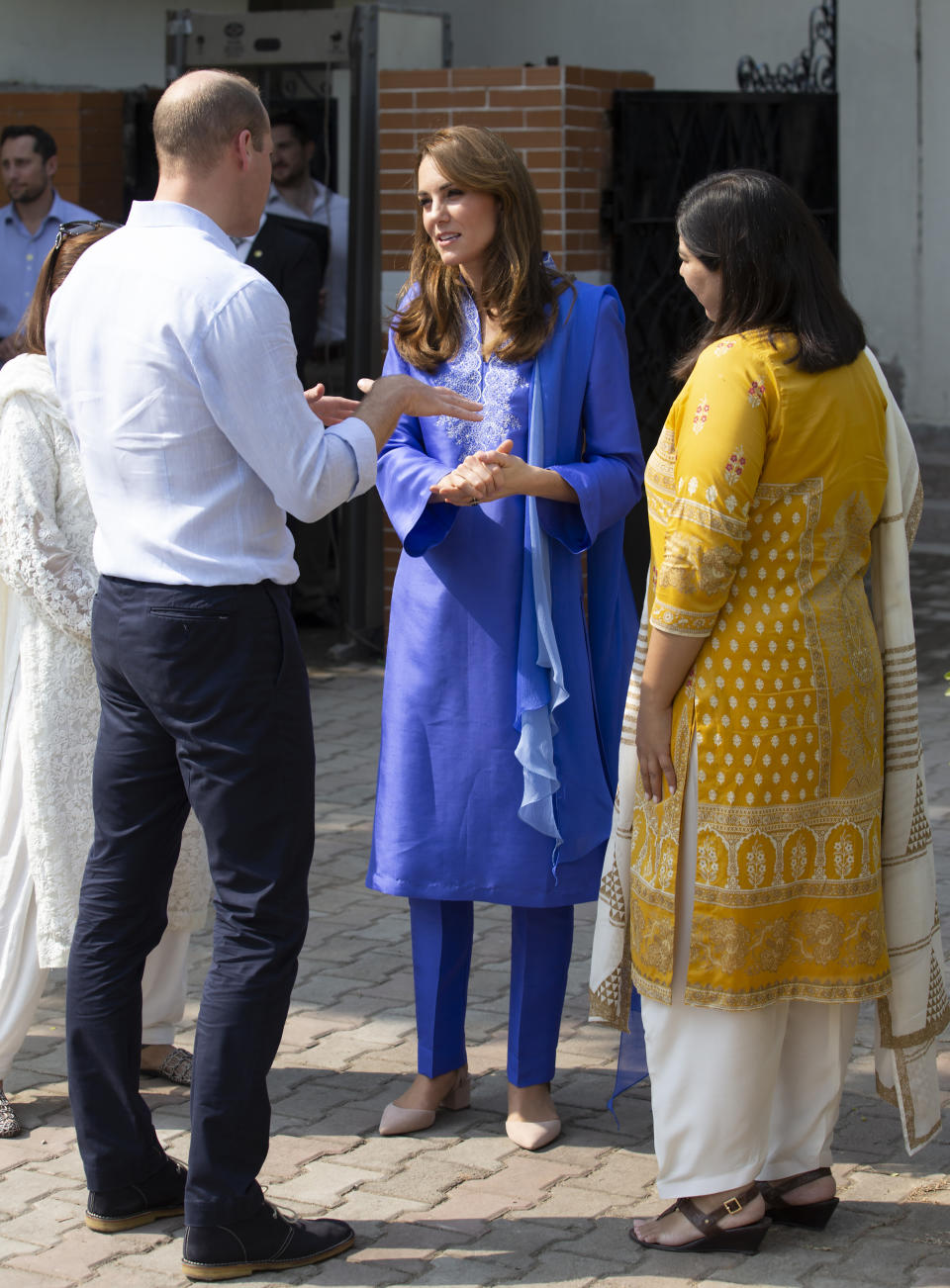 Wearing a traditional Pakistani dress known as the Kurta, Princess Kate speaks to Prince William during visit to a children's school outside of Islamabad, Pakistan, Tuesday, Oct. 15, 2019. The Duke and Duchess of Cambridge, who are strong advocates of girls' education were greeted by teachers and children. (AP Photo/B.K. Bangash)