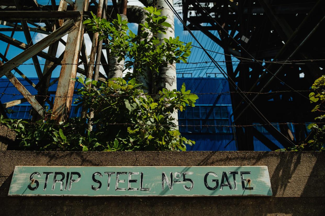 An old Weirton Steel Co. gate sign is still hanging as the ever-present blue of Cleveland-Cliffs mill buildings is seen in the background.