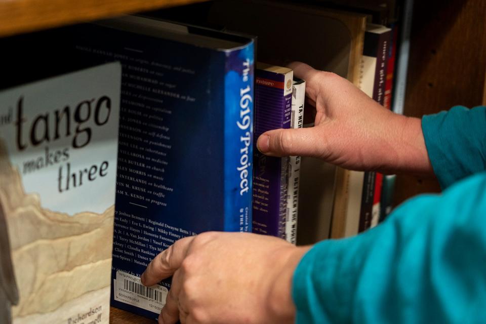 State Rep. Erin Zwiener adds "The 1619 Project" to the bookshelf in her office at the Texas Capitol on Monday, Feb. 13, 2023. The bookshelf holds books that have been banned or yanked from school libraries around the state. 