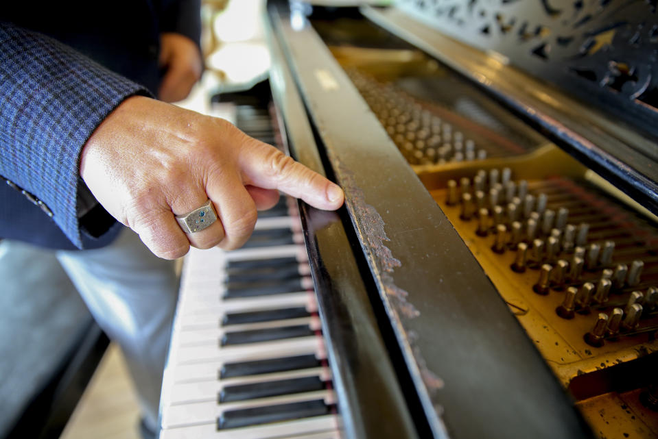 Robert Friedman points out possible bite marks from Thomas Edison on a Steinway grand piano once owned by the inventor, on Sept. 28, 2022, in Woodstock, N.Y. Edison, who was hard of hearing, bit into phonographs and pianos to help him better experience music. Friedman purchased the piano last year and hopes to find a home for it where it can be seen by the public. (AP Photo/Michael Hill)