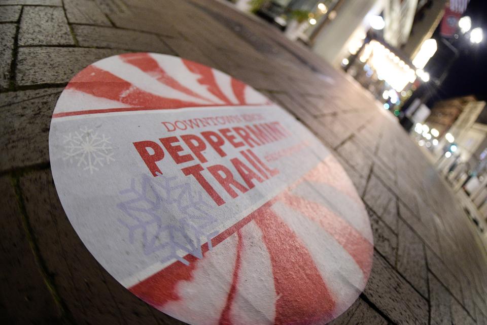 A marker for the Peppermint Trail on Gay Street leads to special holiday treats on the menus and shelves of participating businesses for the annual Christmas in the City light celebration in downtown Knoxville during a past year's holiday season.