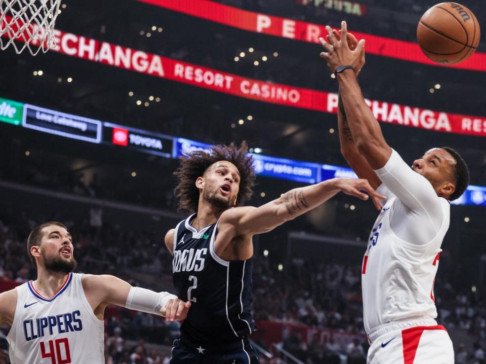 El pívot de los Dallas Mavericks, Dereck Lively II, desvía un rebote del base de los Clippers, Norman Powell