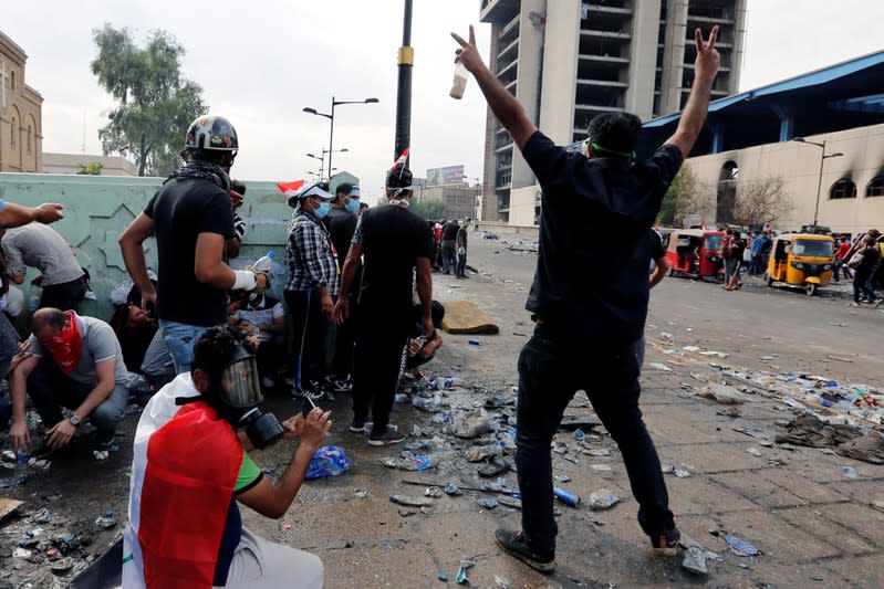 Demonstrators react during a protest over corruption, lack of jobs, and poor services, in Baghdad