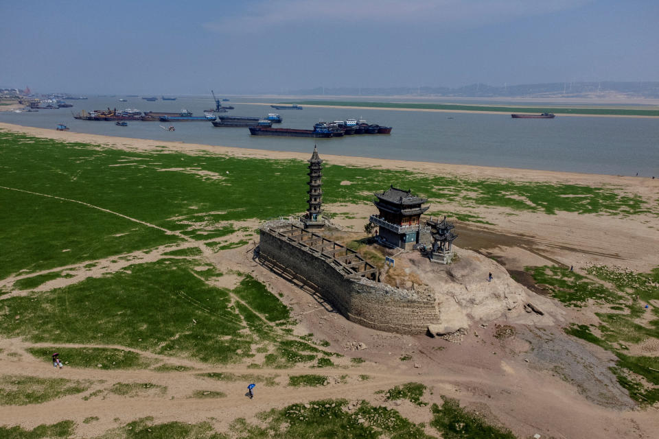 An aerial view shows pagodas on Louxingdun island that usually remain partially submerged in the water of Poyang Lake which is facing low water levels due to a regional drought in Lushan, Jiangxi province, China, August 24, 2022.  REUTERS/Thomas Peter