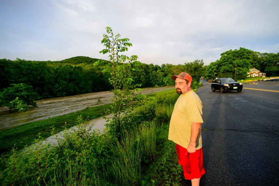 Leonard Derby, of Athens, Vt., watches the floodwaters from the Saxtons River pass through a field on Route 121 in Rockingham, Vt., on Monday, July 10, 2023. Heavy rain has washed out roads and forced evacuations in the Northeast, especially in Vermont and New York. (Kristopher Radder/The Brattleboro Reformer via AP)