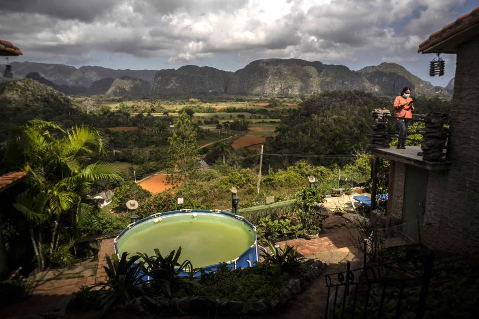 Ivón Deulofeu, a la derecha, cuyo padre es dueño del albergue Cubao Campiña, se encuentra en el balcón de una habitación en Viñales, Cuba, el 1 de marzo de 2021. (AP Foto/Ramón Espinosa)