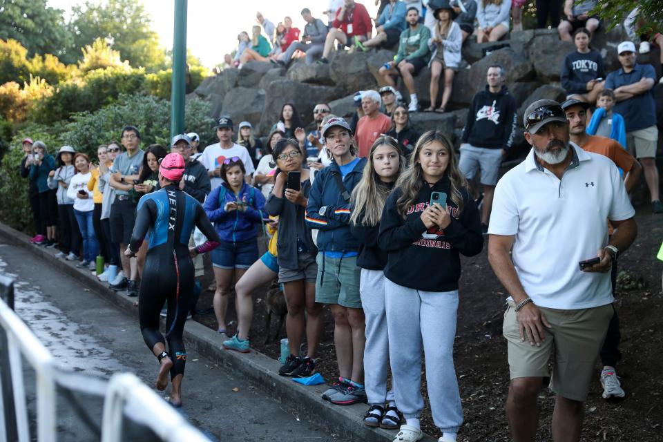 Fans watch July 23 as athletes complete a 1.2 mile swim in the Willamette River during the Ironman 70.3 Oregon.