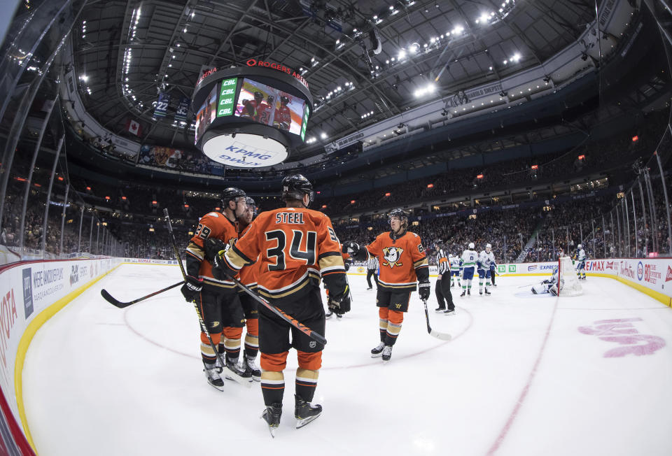 Anaheim Ducks' Devin Shore (29), Sam Steel (34) and Rickard Rakell (67), of Sweden, celebrate Steel's goal against the Vancouver Canucks during the third period of an NHL hockey game Sunday, Feb. 16, 2020, in Vancouver, British Columbia. (Darryl Dyck/The Canadian Press via AP)