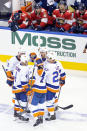 New York Islanders center Mathew Barzal (13) celebrates his goal with teammates as Florida Panthers players look on from the bench during the third period NHL Stanley Cup Playoff qualifying round hockey game in Toronto, Friday, Aug. 7, 2020. (Chris Young/The Canadian Press via AP)