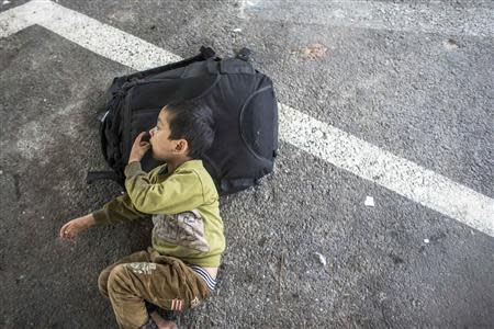 A suspected Uighur from China's troubled far-western region of Xinjiang, rests inside a temporary shelter after being detained at the immigration regional headquarters near the Thailand-Malaysia border in Hat Yai, Songkhla in this March 14, 2014 file photo. REUTERS/Athit Perawongmetha