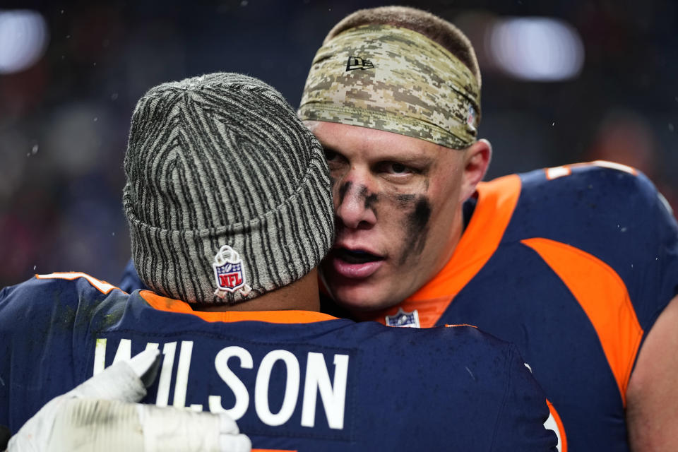 Denver Broncos offensive tackle Garett Bolles embraces quarterback Russell Wilson (3) after an NFL football game against the Minnesota Vikings, Sunday, Nov. 19, 2023, in Denver. The Broncos defeated the Vikings 21-20. (AP Photo/Jack Dempsey)