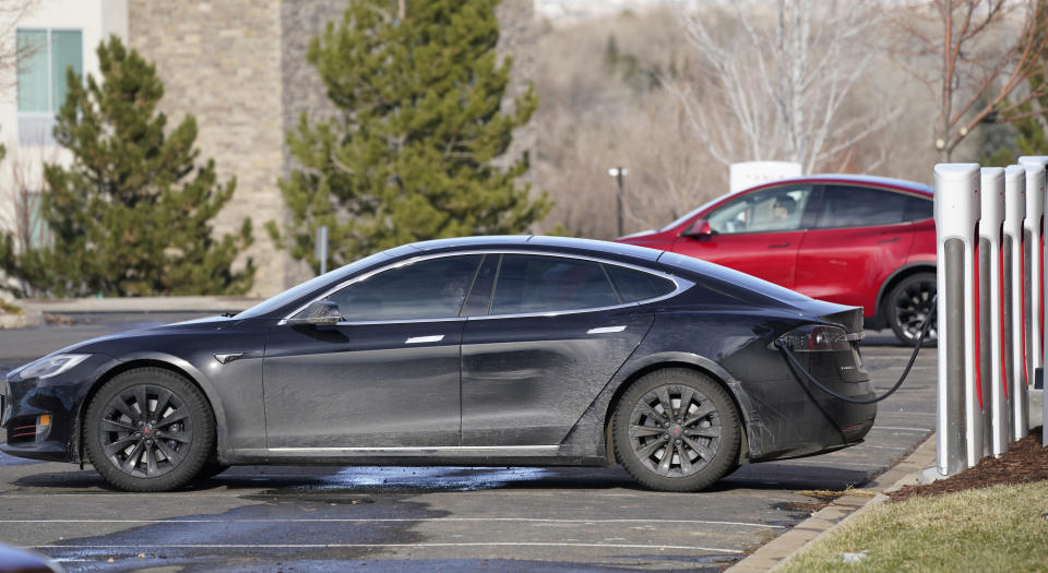 A Tesla Model S, front, and Model Y charge at a Tesla supercharging site outside Colorado Mills outlet mall late Monday, Dec. 21, 2020, in Lakewood, Colo. (AP Photo/David Zalubowski)