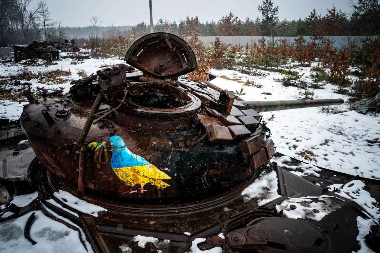 A street-art piece by Italian urban artist TvBoy shows an image of a bird in the colors of the Ukrainian flag painted on a destroyed Russian tank. 