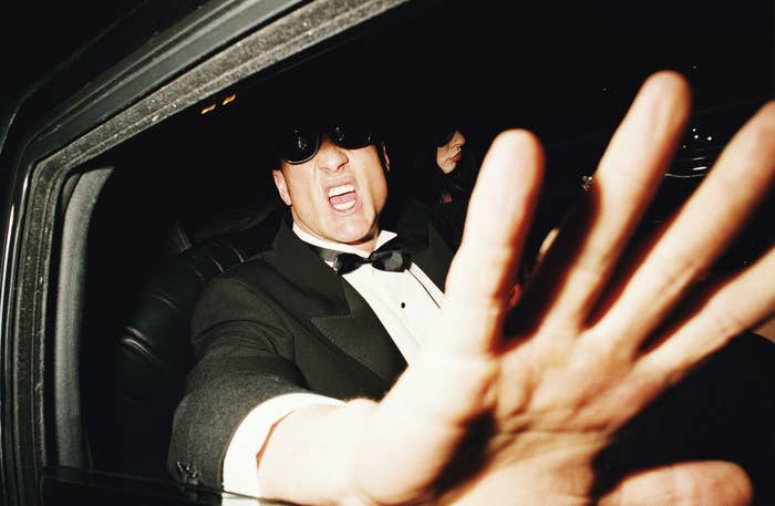 A male celebrity in a car yelling at paparazzi