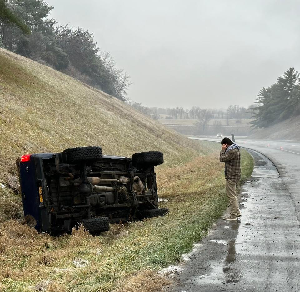 A motorist is seen standing near a vehicle that overturned entering Interstate 64 as it exited I-81 north.