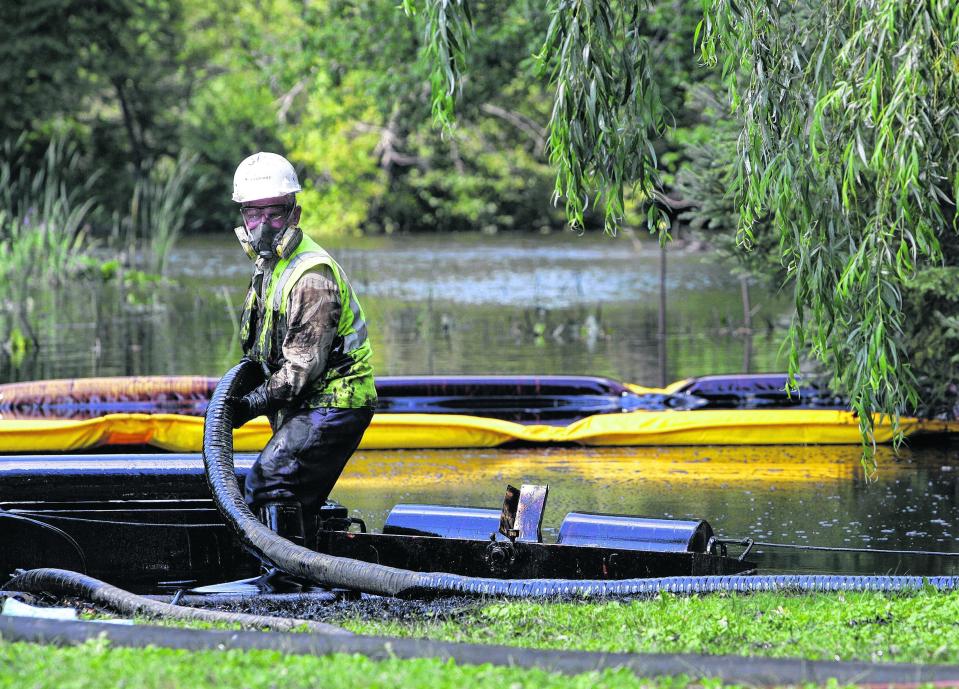 Workers from Enbridge skim oil off the surface of the Kalamazoo River after a pipeline ruptured in Marshall, Mich., in 2010.