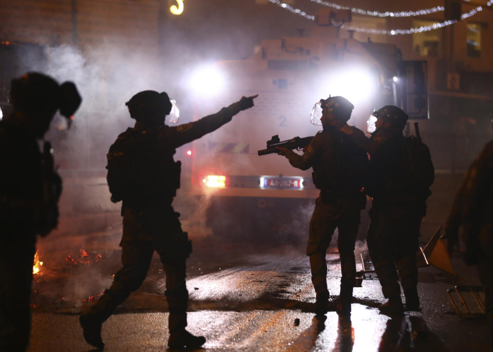 Israeli police officers fire stun grenades toward Palestinian demonstrators during clashes at Damascus Gate just outside Jerusalem's Old City, Saturday, May 8, 2021. (AP Photo/Oded Balilty)