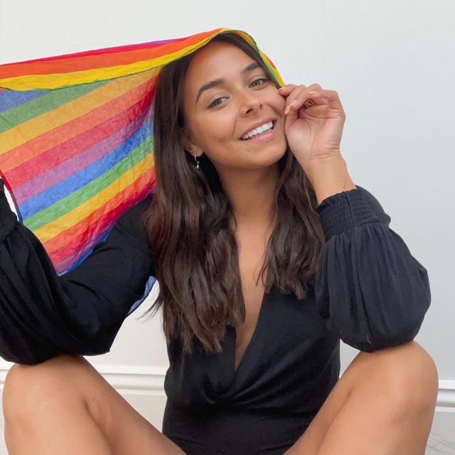 Brooke Blurton posing with a rainbow flag.