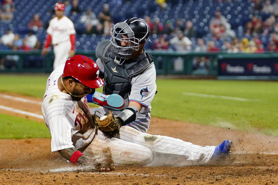 Philadelphia Phillies' Edmundo Sosa, left, scores against Miami Marlins catcher Nick Fortes on an RBI-sacrifice fly by Alec Bohm during the sixth inning of a baseball game, Tuesday, Sept. 6, 2022, in Philadelphia. (AP Photo/Matt Slocum)