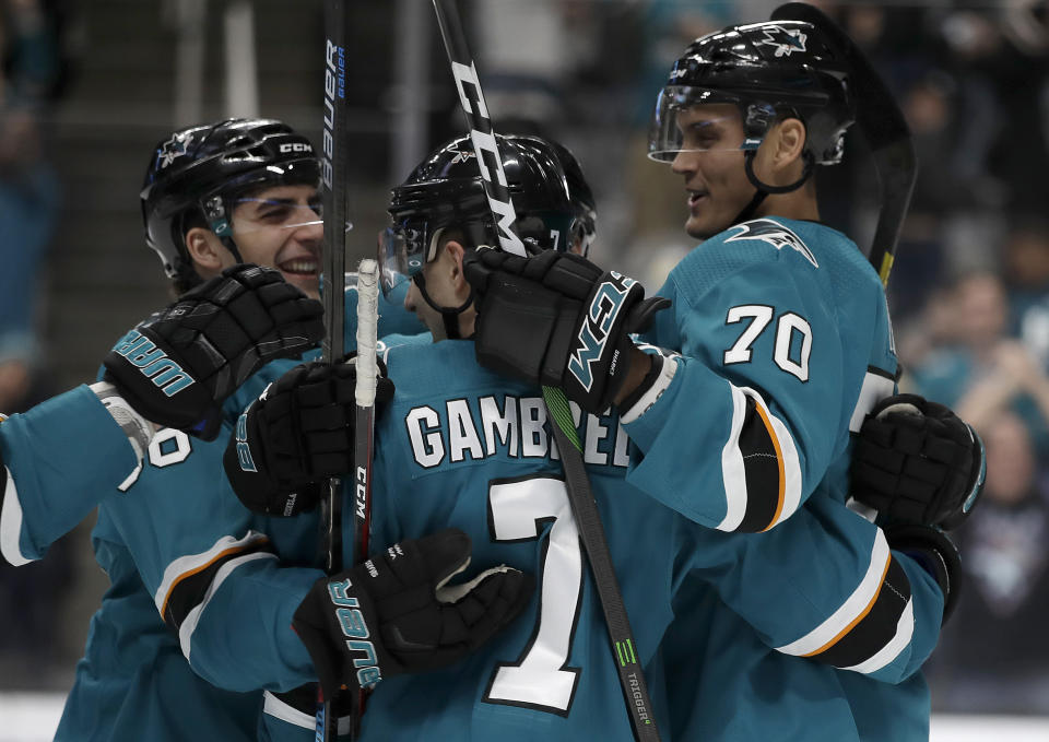 San Jose Sharks' Dylan Gambrell, center, celebrates with Mario Ferraro, left, and Alexander True (70) after scoring against the Florida Panthers in the first period of an NHL hockey game Monday, Feb. 17, 2020, in San Jose, Calif. (AP Photo/Ben Margot)