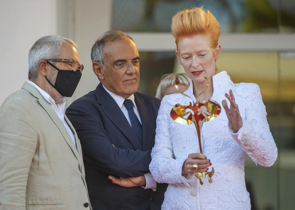 Actress Tilda Swinton, right, talks to festival director Alberto Barbera, center, and the Venice Biennale's president Roberto Cicutto on the red carpet for the movie 'The human voice' during the 77th edition of the Venice Film Festival at the Venice Lido, Italy, Thursday, Sep. 3, 2020. The Venice Film Festival goes from Sept. 2 through Sept. 12. Italy was among the countries hardest hit by the coronavirus pandemic, and the festival will serve as a celebration of its re-opening and a sign that the film world, largely on pause since March, is coming back as well. (AP Photo/Domenico Stinellis)