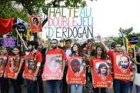 People hold banners and pictures of alleged victims in Paris on July 25, 2015, as they denounce the Suruc bomb blast during a protest called by Kurdish unions