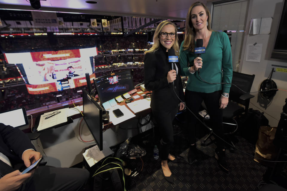 Kate Scott, left, and AJ Mleczko, members of an all-female broadcast team, stand at work during an NHL hockey game between the Chicago Blackhawks and the St. Louis Blues, Sunday, March 8, 2020, in Chicago. They were doing this as part of International Women's Day. (AP Photo/Matt Marton)