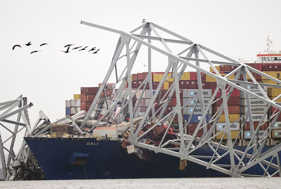 A cargo ship is stuck under the part of the structure of the Francis Scott Key Bridge after the ship hit the bridge Wednesday, March 27, 2024, in Baltimore, Md. (AP Photo/Steve Helber)