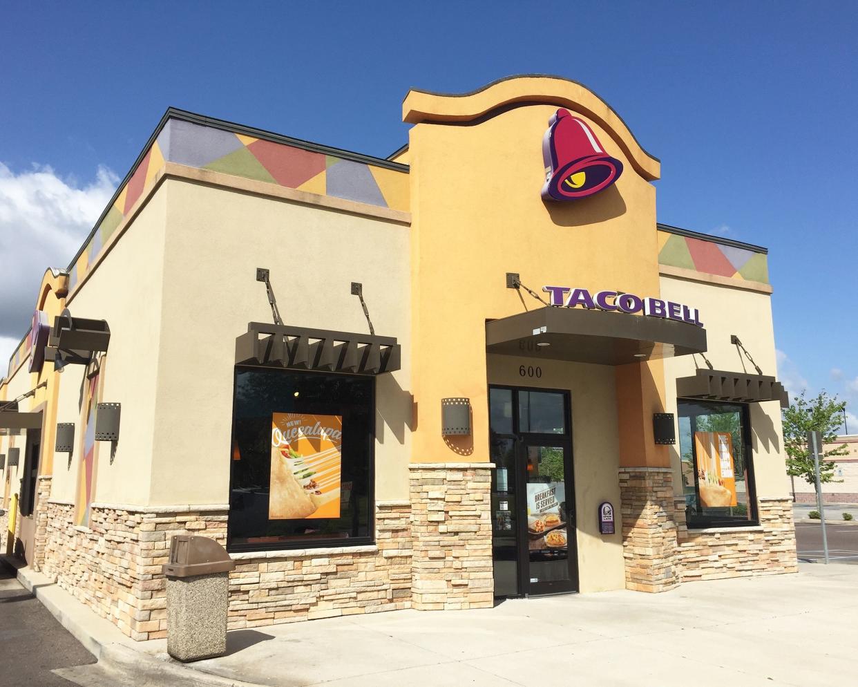 Exterior of a Taco Bell in Jacksonville, Florida, front door and walk area with drive-through window on the left on a bright sunny day