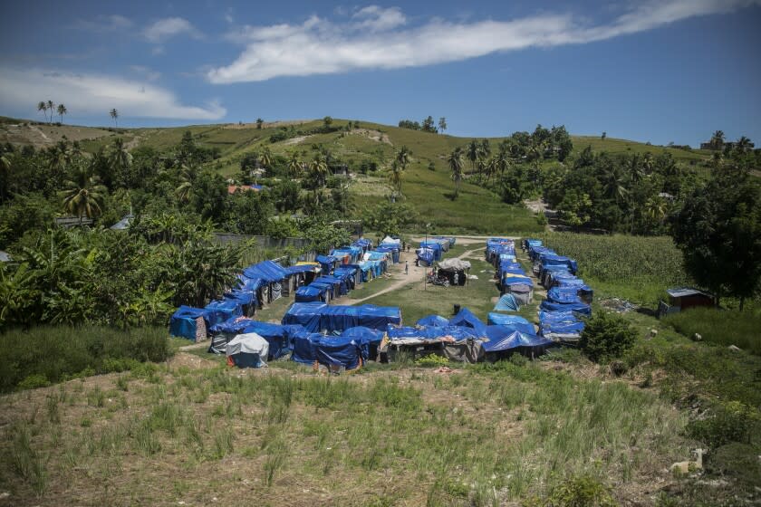 Blue tarps serve as roof coverings in Camp Devirel set up by earthquake refugees in Les Cayes, Haiti, Wednesday, Aug. 17, 2022. A year after a magnitude-7.2 quake hit southern Haiti, the hundreds that were left homeless are still living in the same makeshift tents. (AP Photo/Odelyn Joseph)